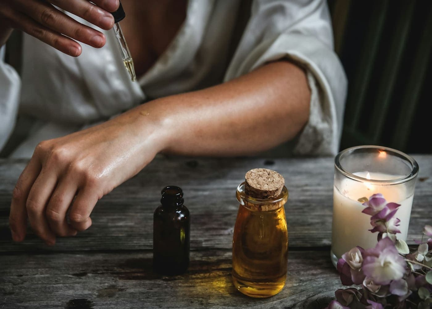 Spa product bottles with botanical ingredients on a neutral surface