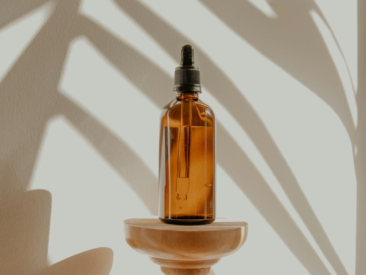 Amber essential-oil bottles and dried lavender for an aromatherapy ritual