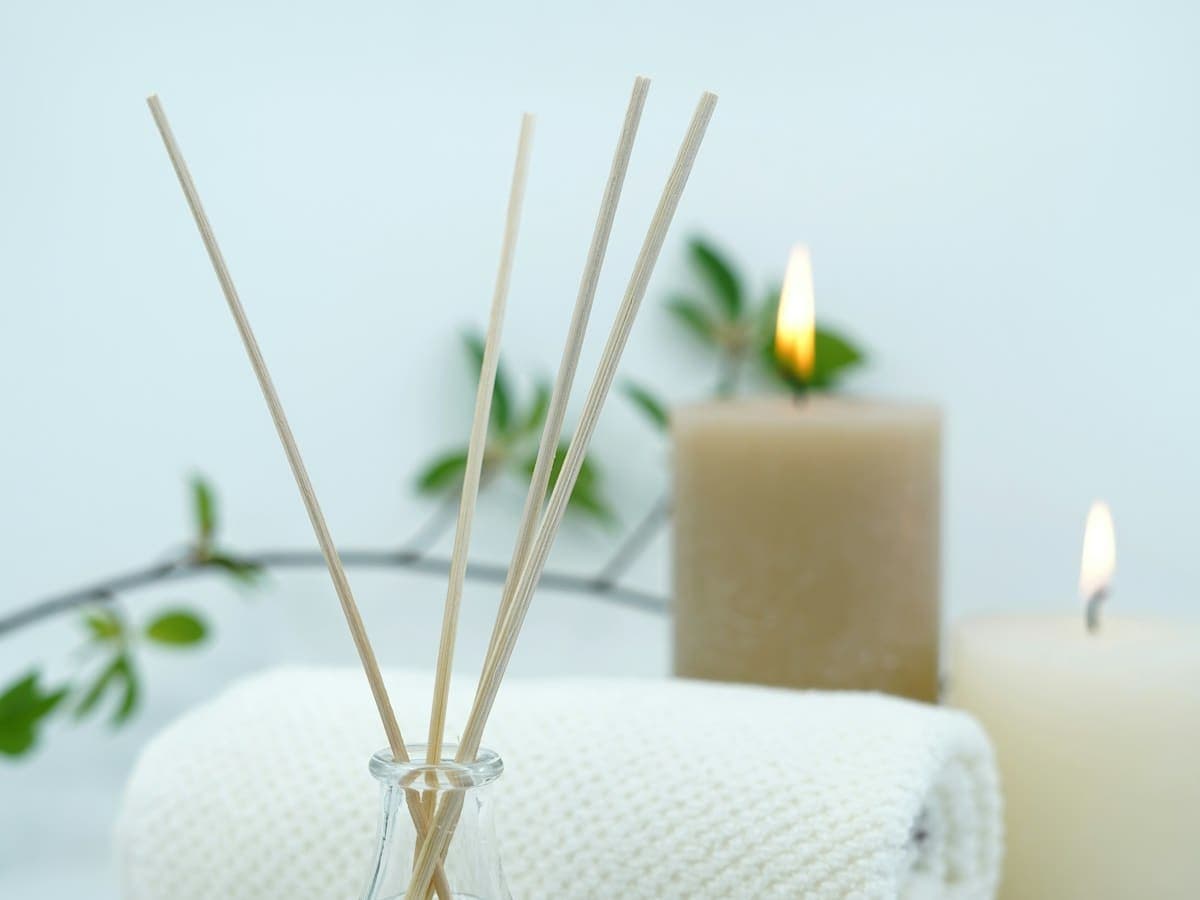 Candlelit ritual setting with botanicals, oils and warm towels
