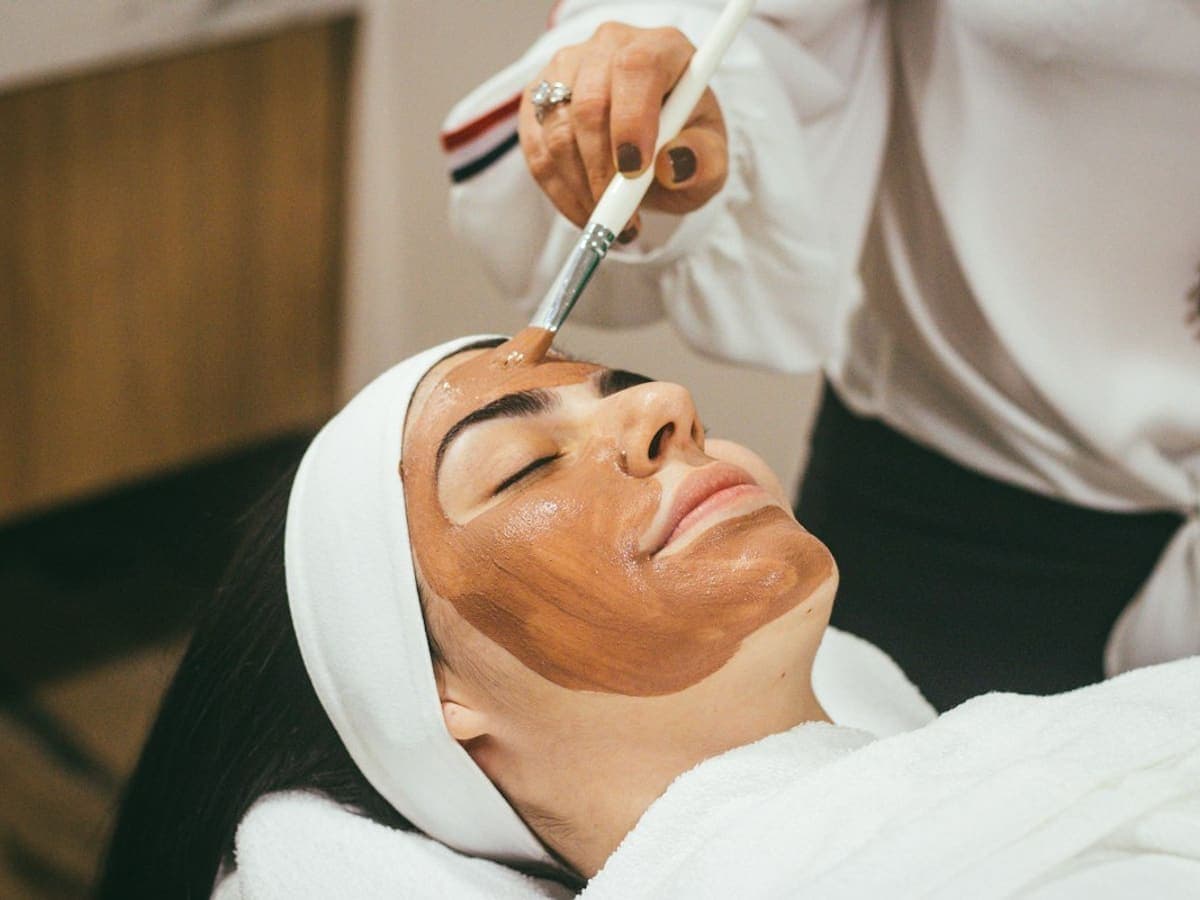 Calm facial treatment with cream and a soft towel in warm lighting